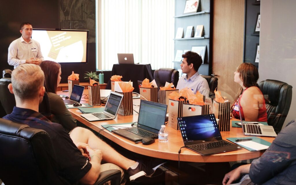 Reunión de trabajo de un equipo alrededor de una mesa con portátiles