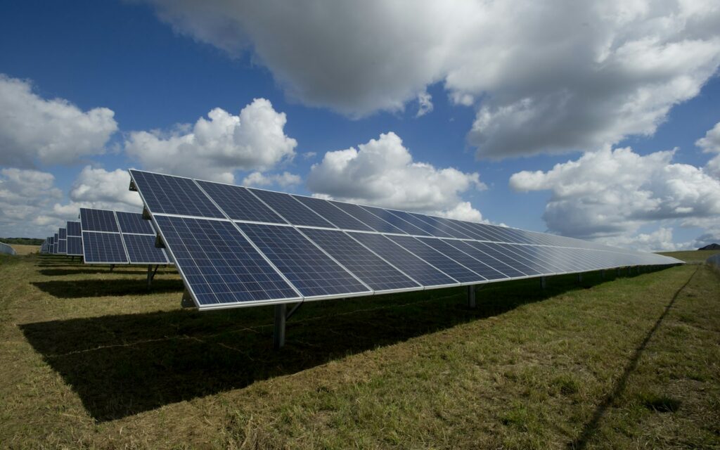 Huerto solar con paneles fotovoltaicos bajo un cielo con nubes
