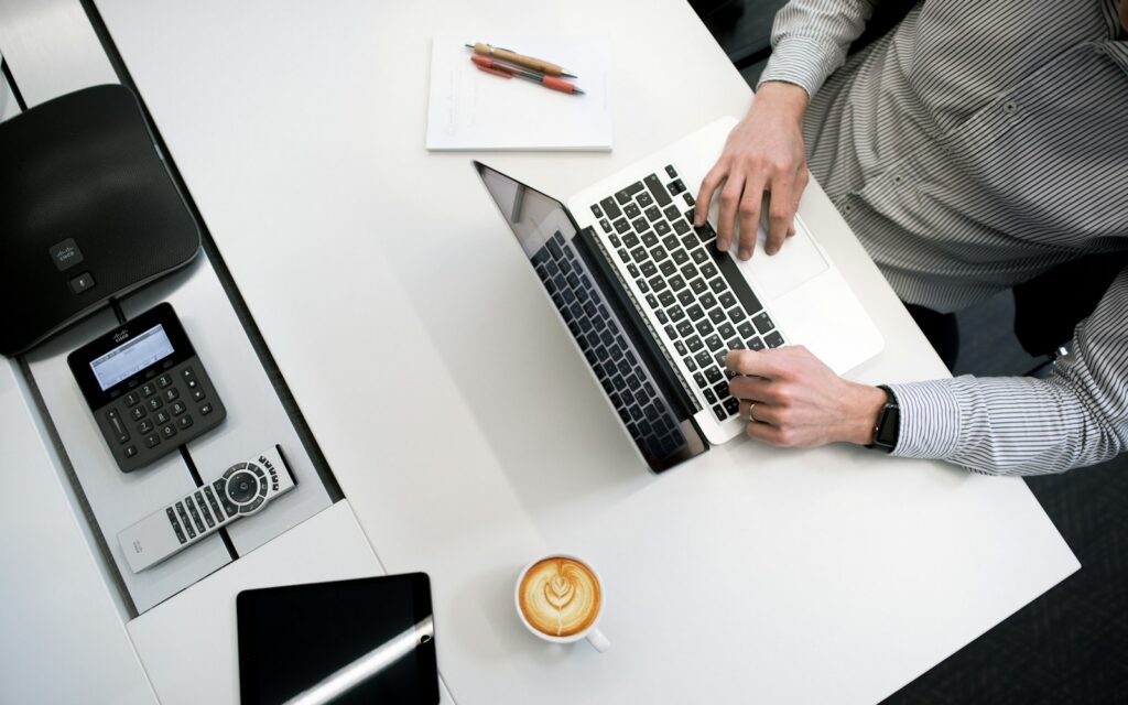 Personne travaillant sur un ordinateur portable à un bureau, vue de dessus